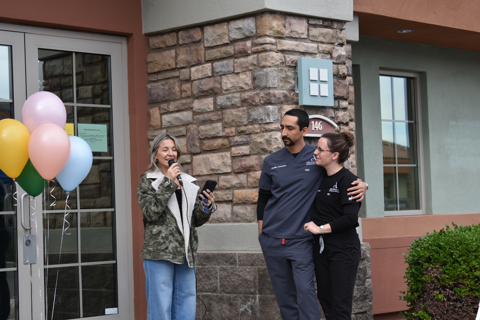 Doctors and a colleague celebrating outside the clinic with balloons